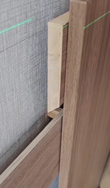 Pannello in legno allineato con livella laser durante il montaggio