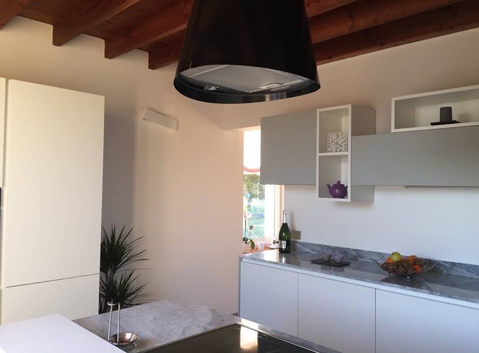 Cucina su misura a Usago: vista d'insieme con penisola, pensili e lampada a sospensione